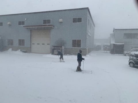 工場の前でスキーを履いて歩く練習